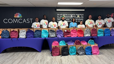 Comcast packs backpacks for the African American Parade Committee’s back-to-school drive, joined by Former State Representative Barbara Norton.