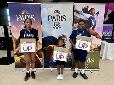 Boys & Girls Club members pose with Olympic-themed medals and laptops donated by Comcast at the Boys & Girls Clubs of Southeastern Michigan Dick & Sandy Dauch Club in Detroit, Michigan.
