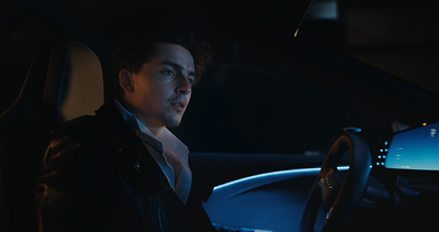 The Groom, portrayed by TimothIe Chalamet, sits inside the cockpit of Lucid Gravity in Lucid’s latest creative campaign, ‒Driven.–