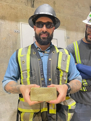 Figure 2 – Vincent-Luc Authier, Construction Manager at TZ with the First Gold Bar Poured at the Mine (CNW Group/G Mining Ventures Corp)