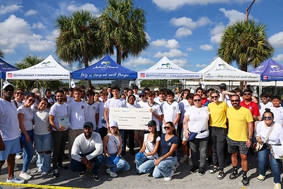 Joshua Williams, joined by Sun Life/DentaQuest and his foundation team members and volunteers, receives the $10,000 check donation.