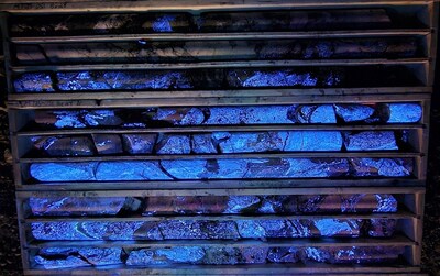 Photo 1: 82.47 m to 91.80 m in MT25-051 displaying high-grade scheelite (CaWO4) mineralization fluorescing under short wave UV. (CNW Group/Fireweed Metals Corp.)