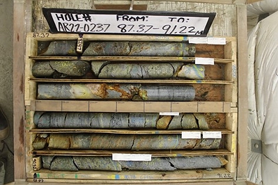 Figure 5. Photos of drill core from hole AR22-0237 showing massive and semi-massive sulphide bands. Close-up photo of exceptionally well mineralized interval  from Zone 5 consisting of medium-grained chalcopyrite with finer-grained interstitial sphalerite hosted within a quartz mica schist cut by quartz vein. Results for sample number 1159796, from 87.83 meters to 88.50 meters, are 15.1% copper, 13.3% zinc, 2.2% lead, 160 g/t silver and 2.7 g/t gold; part of the 10-meter interval of 5.66% copper equivalent reported in Table 1. (CNW Group/Trilogy Metals Inc.)