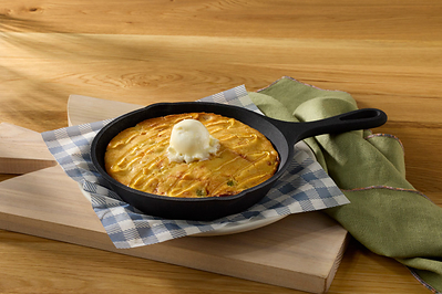 New Green Chile Cornbread barrel bite features cheesy green chile cornbread, drizzled with honey and topped with whipped butter. *Available at select locations only.