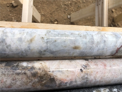 White spodumene at 55 m in the top row and white coarse-grained cleavelandite in the second row, PWM-22-130, West Joe Dyke (CNW Group/POWER METALS CORP)