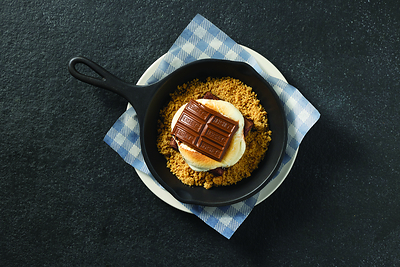 Cracker Barrel Smores Brownie Skillet – A nod to the experience of making s'mores over a campfire, featuring a rich chocolate brownie topped with a roasted marshmallow and a melting HERSHEY'S® Milk Chocolate Bar, all served warm over crumbled graham crackers and paired with a scoop of vanilla ice cream drizzled with chocolate sauce.