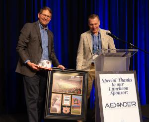 John Eskew is accepting a framed gift from Frank Reiner, president of CI, for his two years of service as Board Chair.