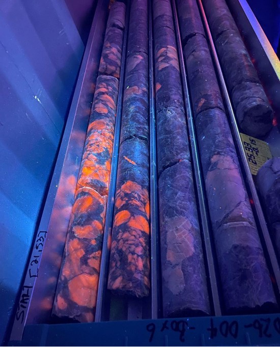 Figure 1: Drill core from NB1DD26-004, 21.0 m to 25.0 m downhole (4.0 m at 2.59% Li2O), showing coarse-grained spodumene pegmatite with dense spodumene mineralization glowing under UV light.